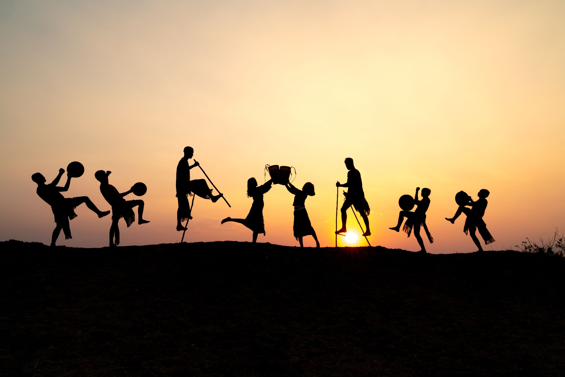 Silhouettes of people celebrating at sunset